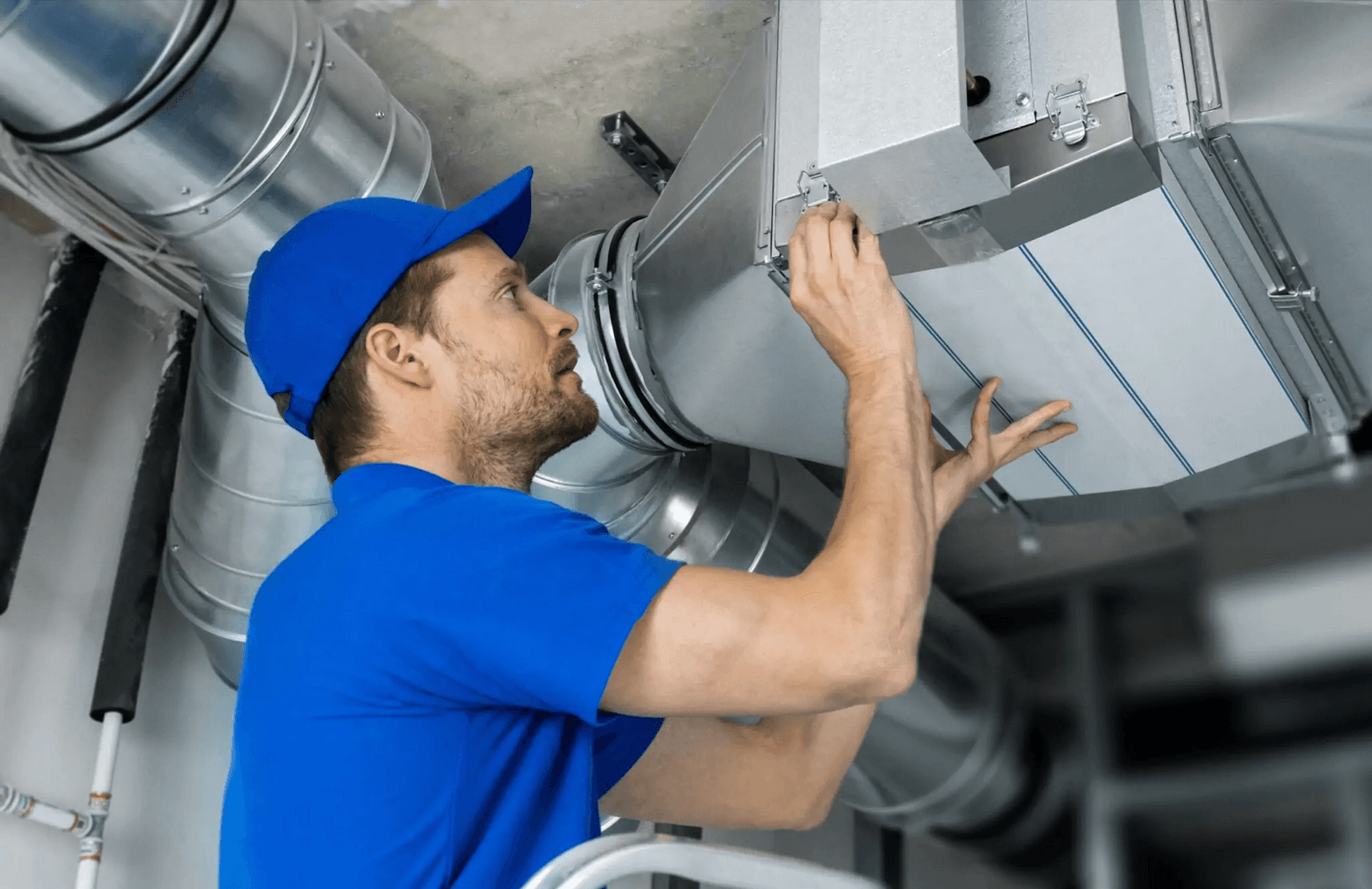 HVAC technician inspecting and adjusting ductwork